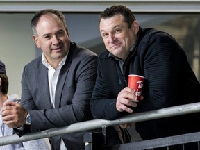 General manager Pierre Dorion (L) and head coach D.J. Smith watch their players at the Ottawa Senators development camp at the Bell Sensplex on June 27, 2019.