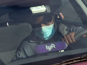 A Lyft driver wears a mask during the coronavirus outbreak, as he leaves passengers in the U.S. Capitol Hill neighbourhood in Washington D.C., April 1, 2020.
