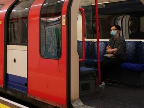 A commuter wearing a mask sits on a train at London Liverpool Street Station, following the outbreak of the coronavirus disease (COVID-19), London, May 13, 2020.