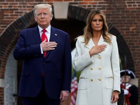 U.S. President Donald Trump and first lady Melania Trump hold their hands over their hearts for the playing of the U.S. National Anthem during ceremonies commemorating the Memorial Day holiday at Fort McHenry in Baltimore, Maryland, May 25, 2020.