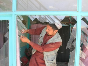 An Afghan man removes broken glass after a blast in Ghazni province, Afghanistan May 18, 2020.