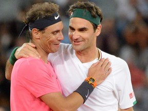 In this file photo Switzerland's Roger Federer, right, hugs Spain's Rafael Nadal during their tennis match at The Match in Africa at the Cape Town Stadium, in Cape Town on Feb. 7, 2020.