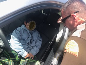 In this photo released by the Utah Highway Patrol, shows an officer speaking to a five-year old boy that was pulled over after driving down the highway in Weber County near Ogden, Utah on May 4, 2020.