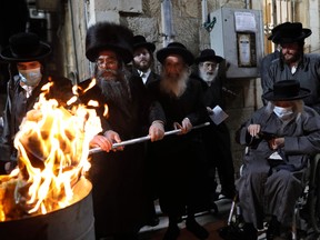 Ultra-Orthodox Jews light a Lag BaOmer bonfire in Jerusalem's religious Mea Shearim neighbourhood amid an Israeli health ministry's order to maintain social distancing and to cancel all Lag BaOmer holiday celebrations, on May 11, 2020, during the COVID-19 pandemic.