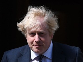 Britain's Prime Minister Boris Johnson exits 10 Downing Street to look at posters, placed in the windows, and drawn by children, of rainbows, being used as symbols of hope during the COVID-19 pandemic, and messages of thanks for the workers of Britain's NHS (National Health Service), in central London on May 15, 2020.