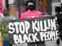 A man holds a 'Stop Killing Black People