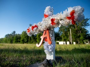 A cross with flowers and a letter A sits at the entrance to the Satilla Shores neighbourhood where Ahmaud Arbery was shot and killed, in Brunswick, Ga., on Thursday, May 7, 2020. Arbery was shot during  a confrontation with an armed father and son on Feb 23.