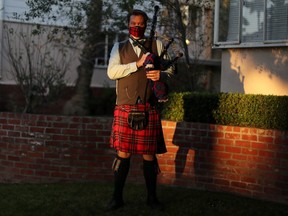 Andrew McGregor, 40, poses for a photo before his evening bagpipe performance of “Amazing Grace” at sunset for the neighborhood in Santa Monica, California, May 11, 2020.