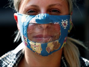 Student advisor Annalore poses with a partially transparent mask used to communicate with students at the Royal Institute for the Deaf Mute in Brussels, May 4, 2020.
