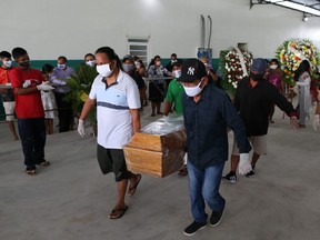 Mourners from the Parque das Tribos community carry the coffin at the funeral of Chief Messias, 53, of the Kokama tribe who died victim of the new coronavirus, COVID-19, in Manaus, Brazil, on May 14, 2020.