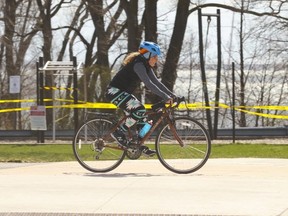 A cyclist gets in some exercise along the Martin Goodman Trail near the Argo Rowing club past taped-off lakeside parkland on Thursday, April 9, 2020.