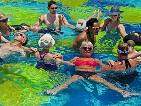 Tourists participate in noontime water aerobics in the hotel pool while vacationing at the Pueblo Bonito Rose resort on Medano Beach May 12, 2012 in Cabo San Lucas, Mexico.