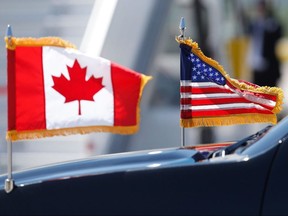 In this file photo taken on June 8, 2018, a limousine drives with U.S. and Canadian flags in Bagotville, Quebec, for the G7 summit.