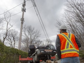 Technicians repair a cell tower after a fire that police are calling suspicious, Monday May 4, 2020, in Piedmont, Que.