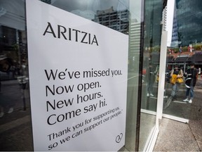 People wait to enter an Artizia clothing store on its first weekend open after a lengthy closure due to COVID-19, in Vancouver, on Sunday, May 17, 2020.