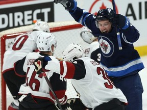 Jets defenceman Tucker Poolman (right) celebrates his goal against the Coyotes during NHL action in Winnipeg on March 9, 2020.