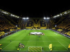 In this file photo taken on February 18, 2020 Dortmund fans display their team's logo as the teams walk in prior to the UEFA Champions League math against Paris Saint-Germain.
