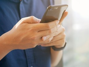 A man types a message on his cellphone.