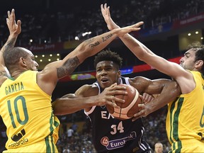 Greece's Giannis Antetokounmpo, centre, tries to handle the ball through Brazil's Alex Garcia, left, and Brazil's Vitor Benite during the Basketball World Cup Group F game between Brazil and Greece in Nanjing on Sept. 3, 2019.