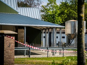 This general view shows barrier tape cordoning off buildings of a mink farm at Beek en Donk, eastern Netherlands on April 26, 2020, after tests showed that animals within had been infected with the new coronavirus (COVID-19).