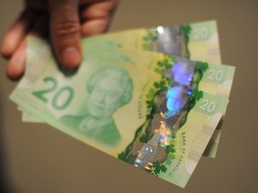 A man displays Canadian $20 bills in Washington, D.C., on Jan. 14, 2013.