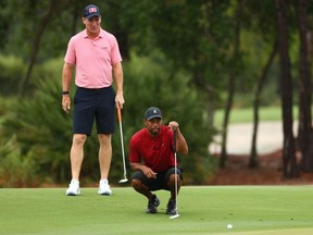 Tiger Woods and former NFL player Peyton Manning read a putt on the sixth green during The Match: Champions for Charity golf round at the Medalist Golf Club.