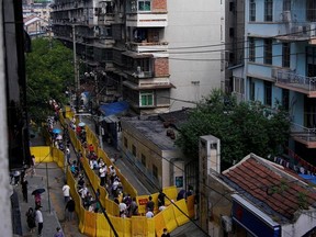 Residents wearing face masks line up for nucleic acid testings at a residential compound in Wuhan, the Chinese city hit hardest by the coronavirus disease (COVID-19) outbreak, Hubei province, China May 17, 2020.