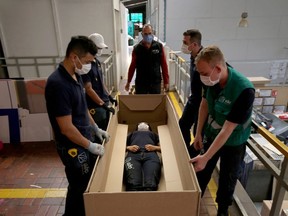 Employees of the company "ABC Display" demonstrate how a hospital bed that they manufacture is transformed into a cardboard coffin, amid the coronavirus disease (COVID-19) outbreak in Bogota, Colombia May 21, 2020.