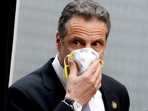 New York Governor Andrew Cuomo holds a protective mask to his face as he arrives for a daily briefing at New York Medical College during the outbreak of the coronavirus disease (COVID-19) in Valhalla, New York, U.S., May 7, 2020.