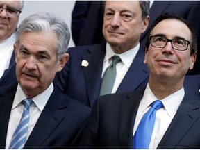 U.S. Treasury Secretary Steve Mnuchin (R) and Federal Reserve Chairman Jerome Powell pose for G-20 finance ministers and central banks governors family photo during the IMF/World Bank spring meeting in Washington, U.S., April 20, 2018.