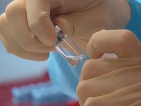 A scientist cleans vaccine vials at the Clinical Biomanufacturing Facility (CBF) in Oxford, Britain, April 2, 2020.