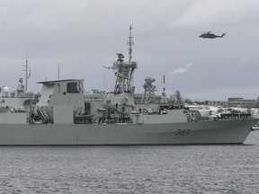 A Cyclone helicopter flies over HMCS Fredericton as its crew leaves the Halifax Harbour for a six-month deployment to the Mediterranean Sea as part of NATO's Operation Reassurance in Halifax on Monday, January 20, 2020.