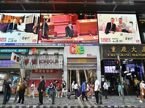 China's President Xi Jinping (top C) is shown on a large video screen in Hong Kong on May 28, 2020, during a live broadcast of the National Peoples Congress (NPC) in Beijing.