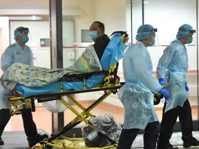 Medical staff transfer a patient of a suspected case of a new coronavirus at the Prince of Wales Hospital in Hong Kong, Jan. 22, 2020.