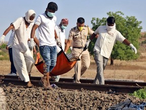 People carry the body of a victim after a train ran over migrant workers sleeping on the track in Aurangabad district in the western state of Maharashtra, India, May 8, 2020.