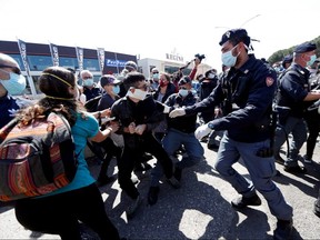 Police surround protesters wearing protective face masks as they demonstrate outside the Rebibbia prison to demand better sanitary conditions for prisoners inside the jail in Rome April 16, 2020.