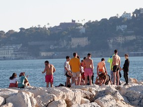 People are seen at the seaside, as Italy begins a staged end to a nationwide lockdown due to the spread of COVID-19, in Naples, Italy, May 4, 2020.