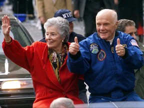 Astronaut John Glenn gives the thumbs up as he rides in an open car with his wife Annie during a ticker tape parade down New York's "Canyon of Heroes" in New York on November 16, 1998.