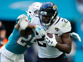 Leonard Fournette of the Jacksonville Jaguars tries to avoid the tackle of Minkah Fitzpatrick of the Miami Dolphins at Hard Rock Stadium on December 23, 2018 in Miami.