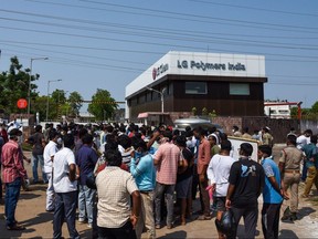 People gather in front of an LG Polymers plant following a gas leak incident in Visakhapatnam on May 7, 2020.