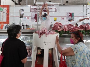 A butcher sells meat using face mask at Martínez de la Torre market on May 18, 2020 in Mexico City, Mexico.