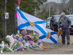 A man pays his respects at a roadside memorial in Portapique, N.S. on Thursday, April 23, 2020.