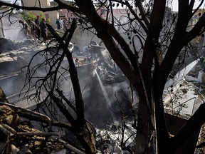 Firefighters spray water on the wreckage of a Pakistan International Airlines aircraft after it crashed in a residential area in Karachi on May 22, 2020.