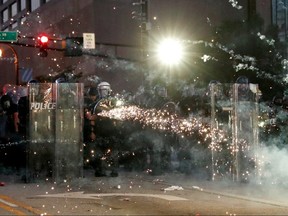 Protesters throw firecrackers amid tear gas during a protest against the death in Minneapolis police custody of George Floyd, in Atlanta, May 30, 2020.