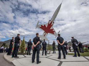 Kamloops firefighters stand during a minute of silence during a tribute ceremony to honour Capt. Jennifer Casey at the Kamloops Airport Thursday May 21, 2020.