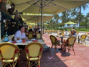 People sit at Il Giardino as restaurants reopen with restrictions to limit the spread of the coronavirus disease on Ocean Drive on South Beach in Miami May 27, 2020.