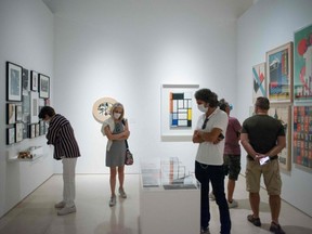 People wearing masks visit an exhibition at the Picasso Museum on May 27, 2020.