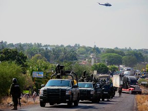 Soldiers of Mexican Army patrol the entrance of the Buenavista Tomatlan during an operation to search for criminals in the area called "Tierra Caliente" (Hot Land) in Michoacan State, Mexico on May 22, 2013.