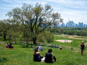 Park visitors soak up the sun in Toronto on Saturday, May 23, 2020.