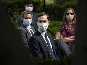 White House advisor Jared Kushner (middle) and others wear face masks while attending a press briefing about coronavirus testing in the Rose Garden of the White House on May 11, 2020 in Washington.